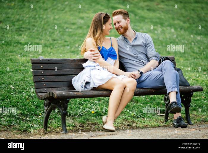 Romantic couple in love sitting on park bench Stock Photo - Alamy