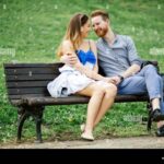 Romantic couple in love sitting on park bench Stock Photo - Alamy